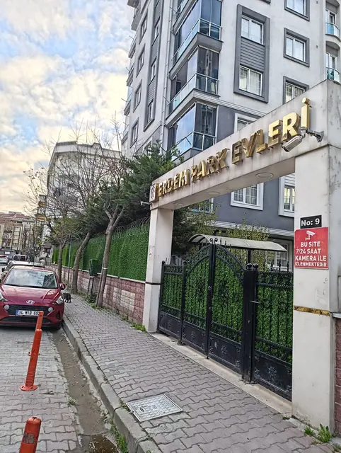 Site giriş kapısı ve cephe duvarı boyunca uzanan çim çit